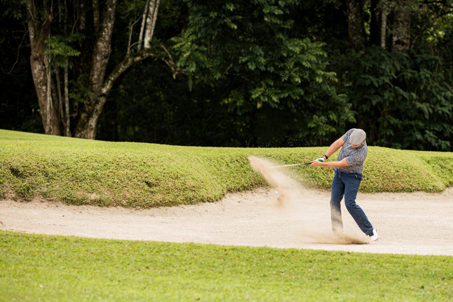 Professional golfer. hits the ball from the sand trap