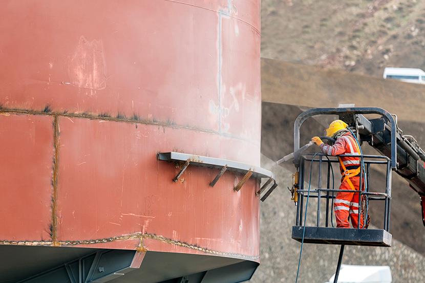 worker sandblasting the exterior of a steel tank 1 4 1